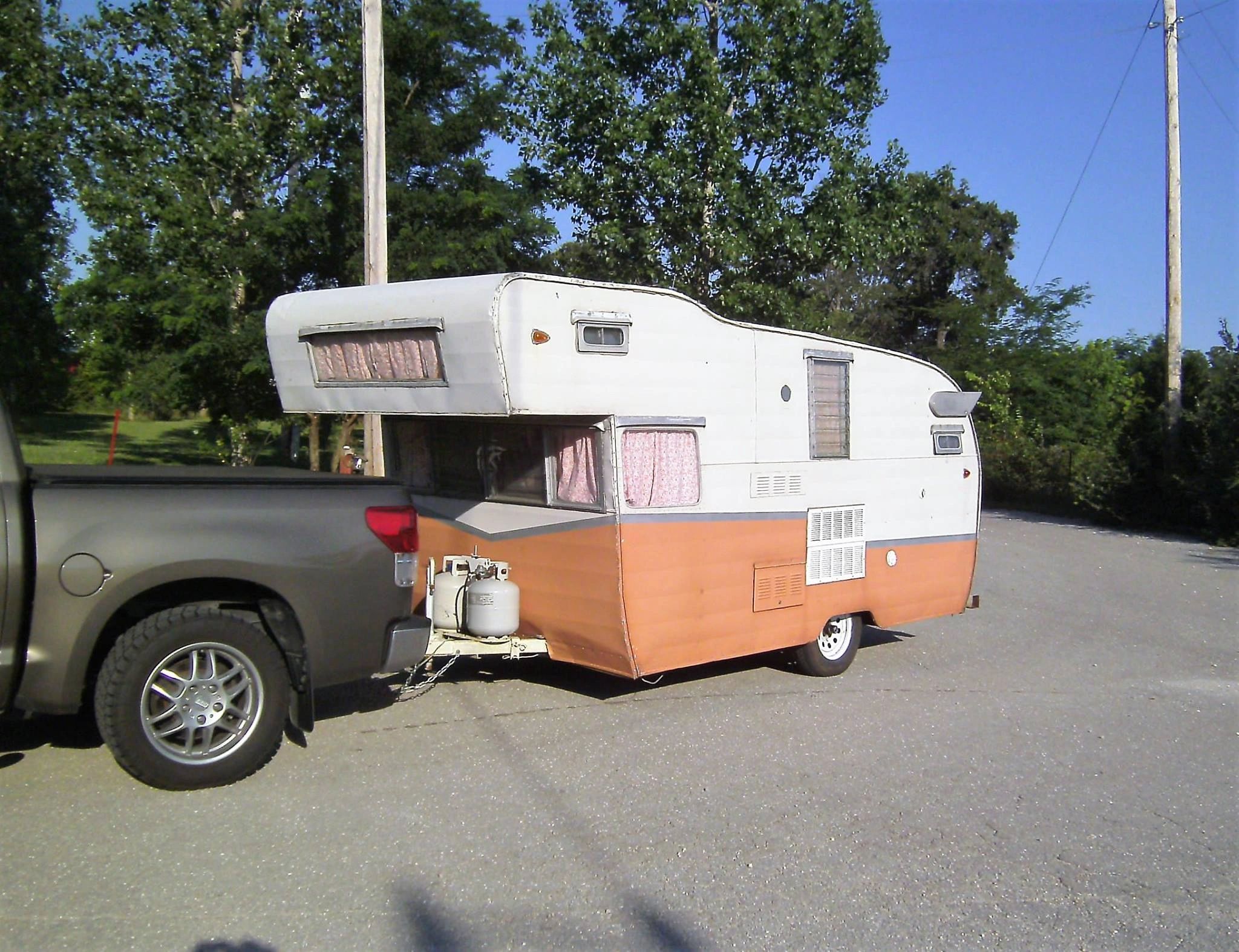 RV travel trailer parked at Lamplight RV Park campsite at sunset
